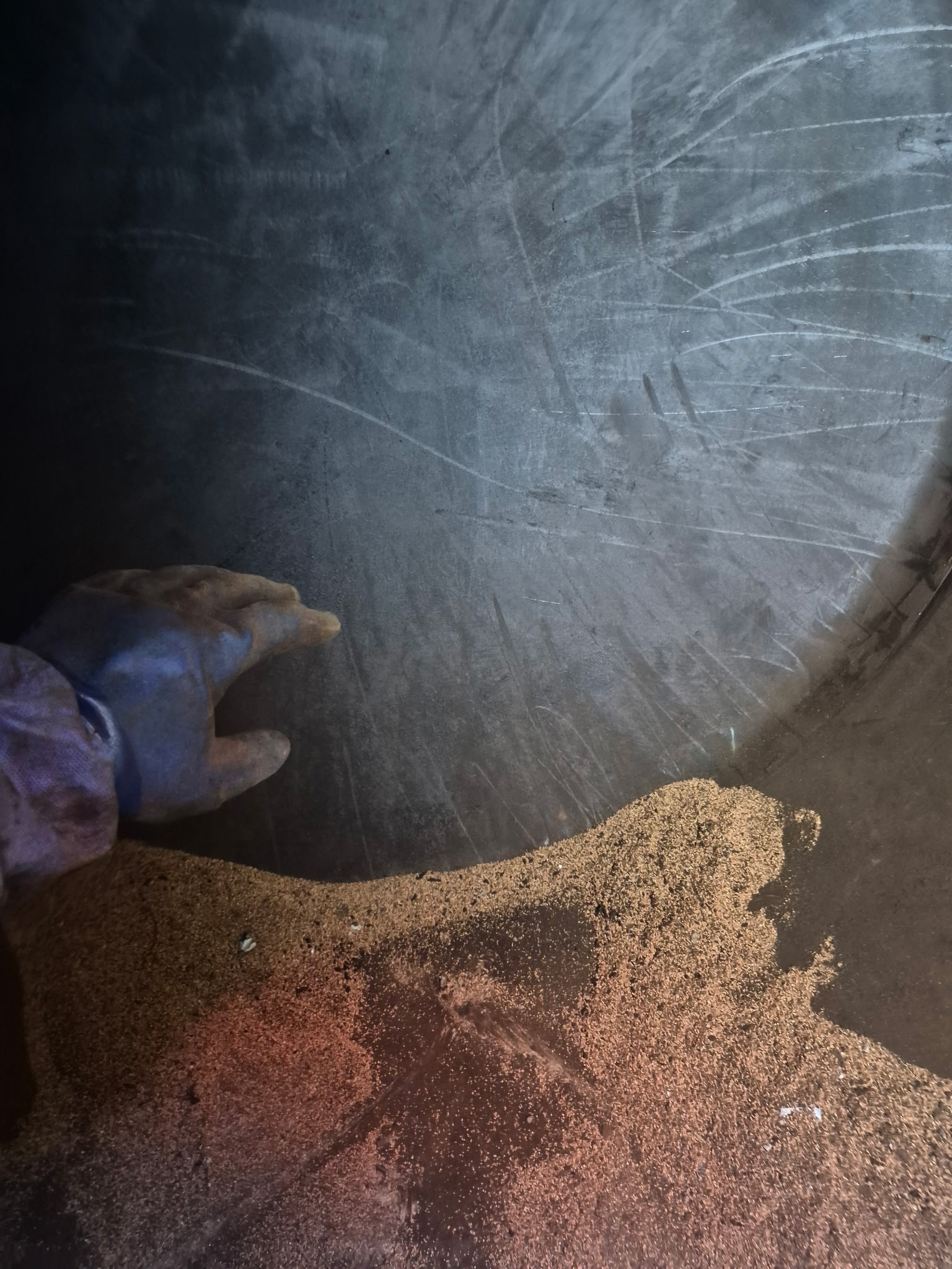Cuve à fuel de 3000 litres en phase de nettoyage : le technicien à l'intérieur de la cuve procède au grattage des boues avec un matériau abrasif.